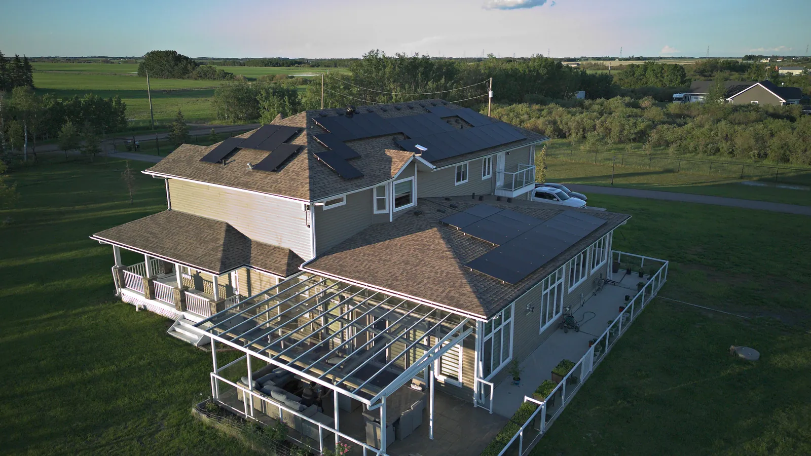 Aerial view of a Stellar Upgrades rooftop solar installation on an Alberta acreage home at golden hour